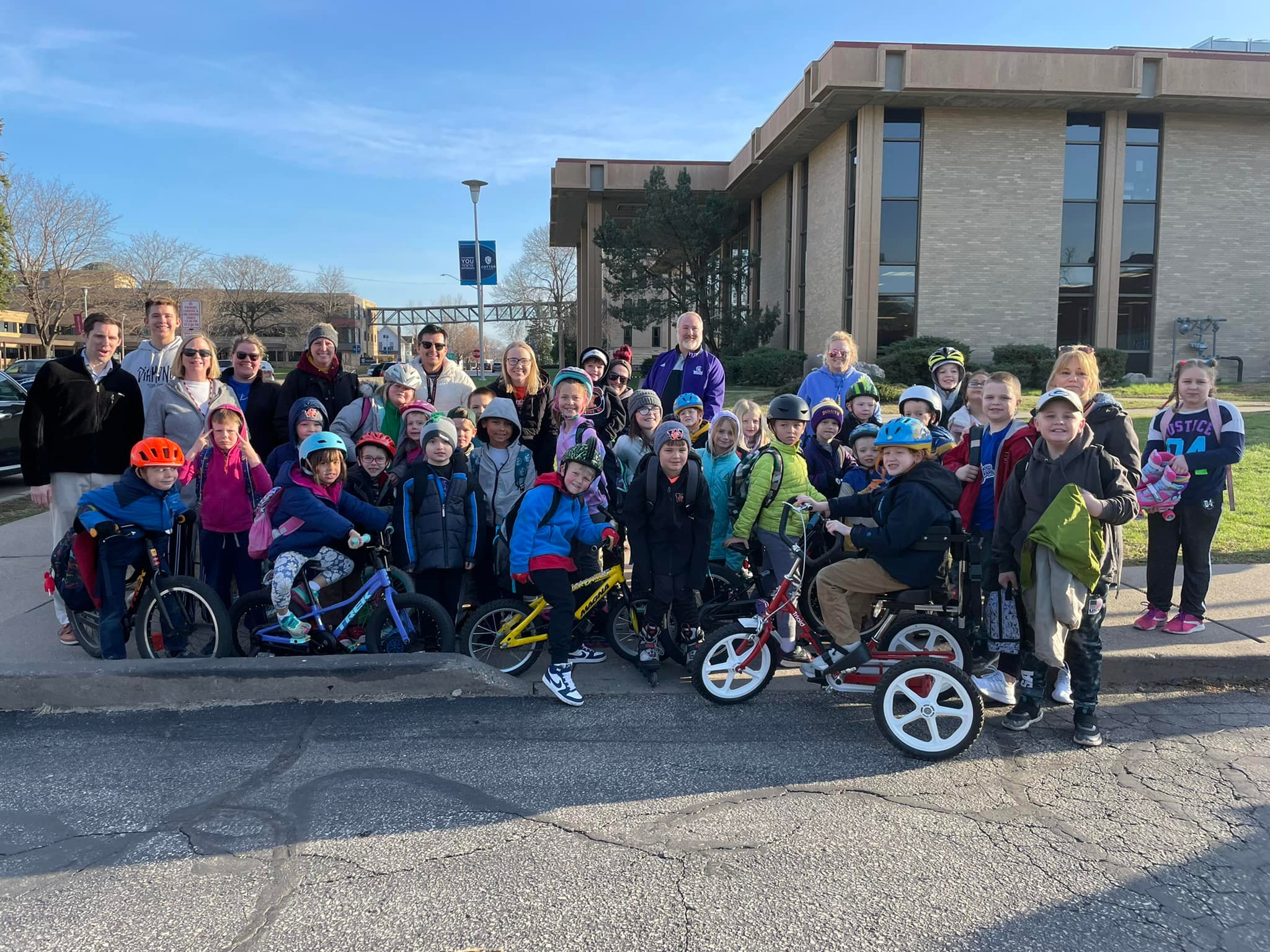 A group of students, educators, and families gathered for a photo with their bikes and scooters in Winona, Minnesota.
