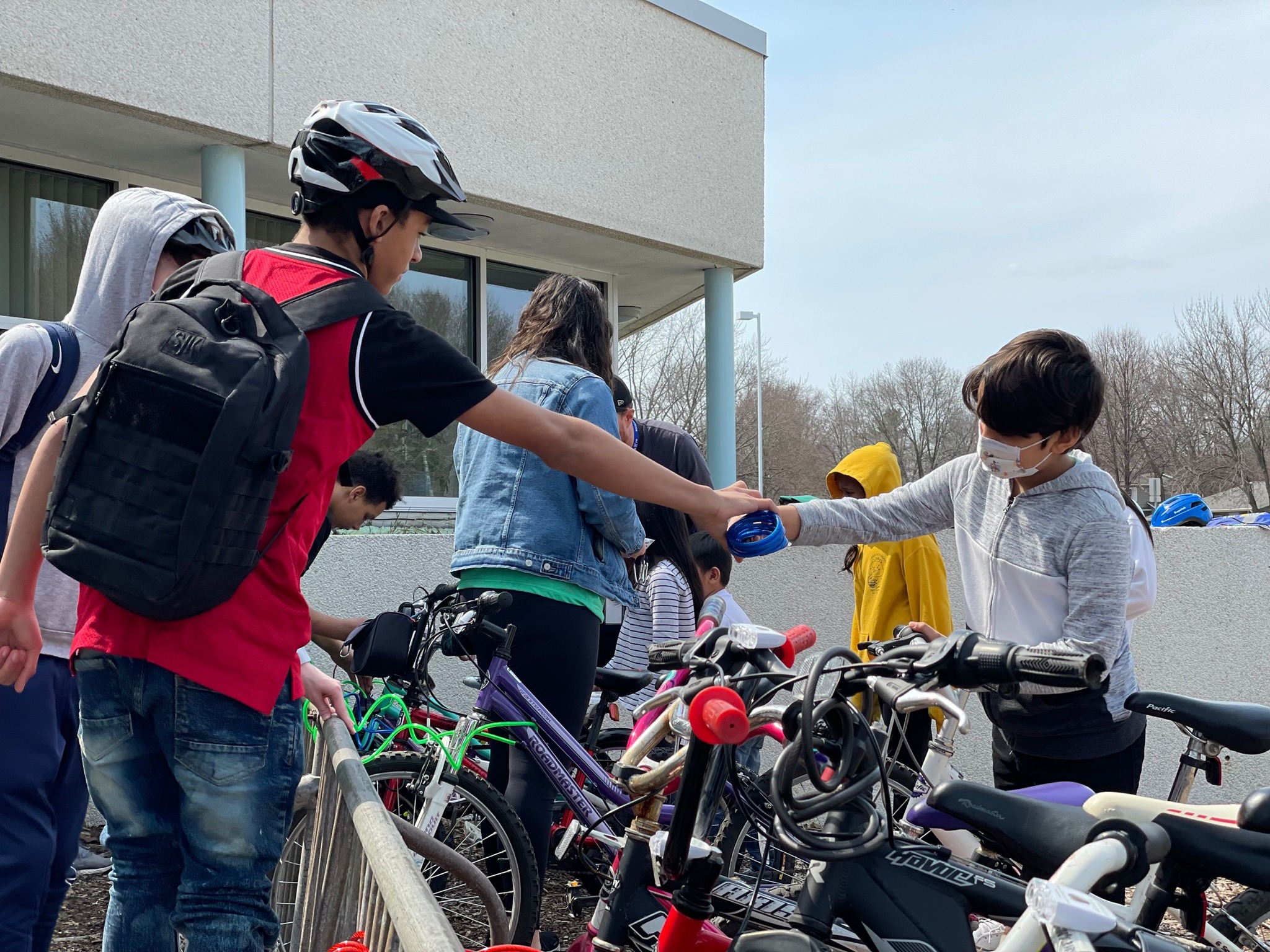 A student passes a wire lock to another student to help lock up their bikes in Rochester, Minnesota. 